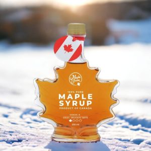 Bouteille de sirop d'érable en forme de feuille d'érable dans la neige